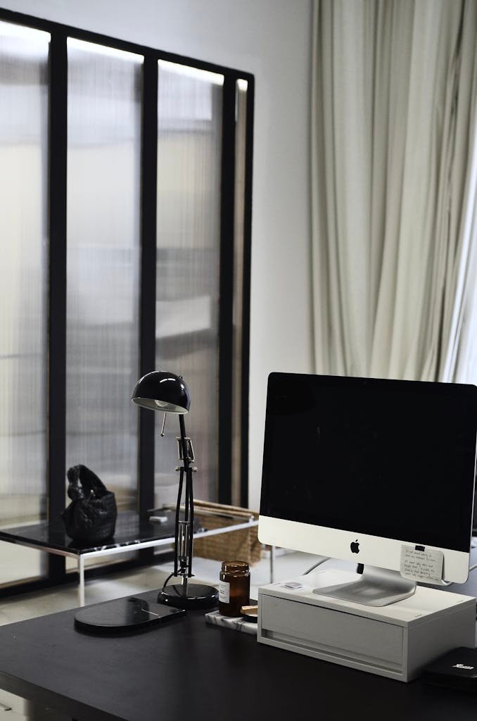 Interior of contemporary workplace of office with convenient computer and lamp on table